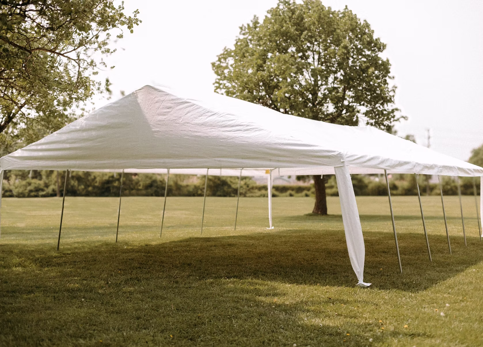 23 by 40 foot white banquet tent set up on grass.