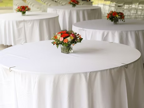 Round dining tables draped in white linens with floral centerpieces.